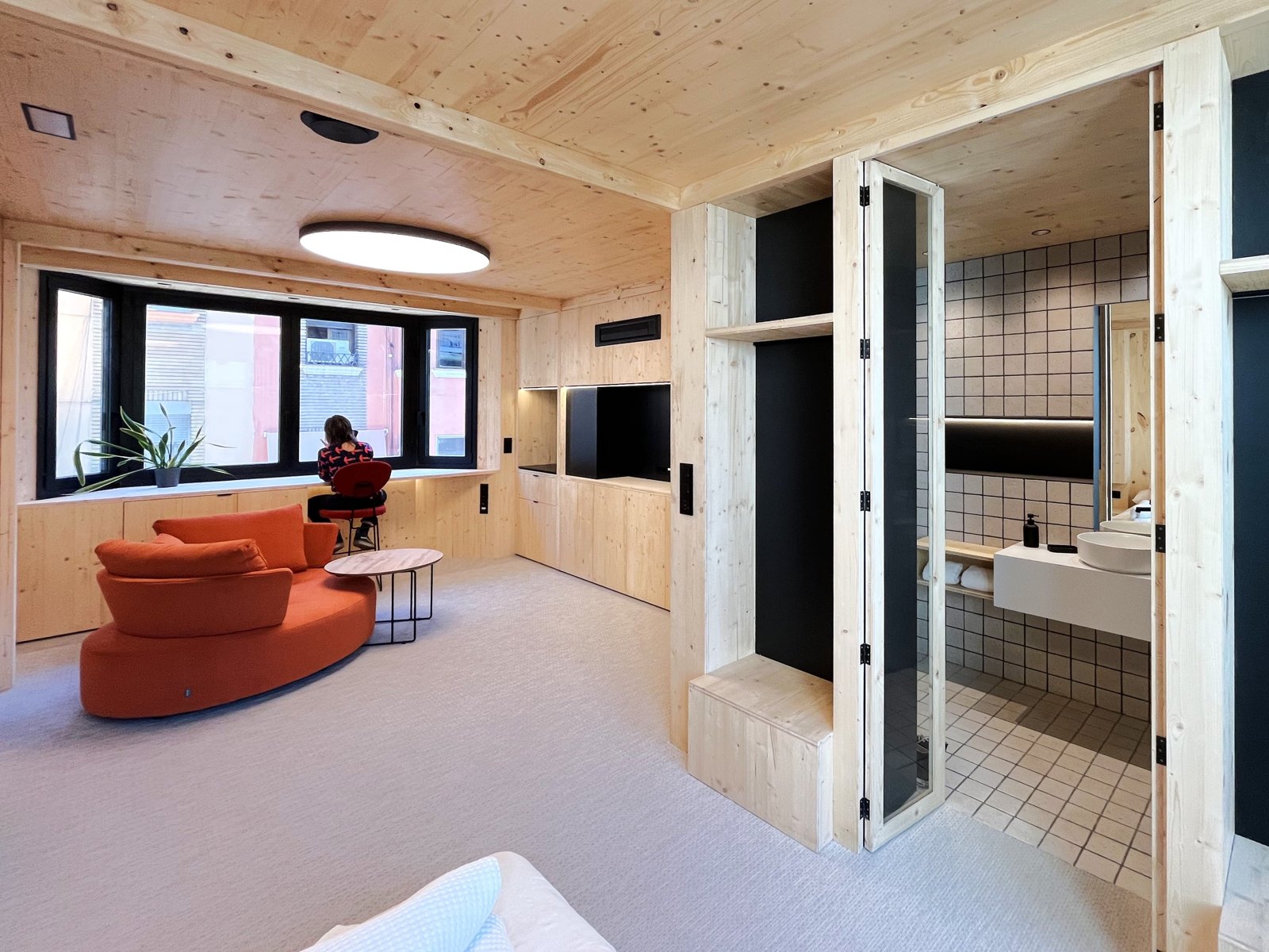 Vista interior de una suite terminada con salón, cocina y acabados de madera